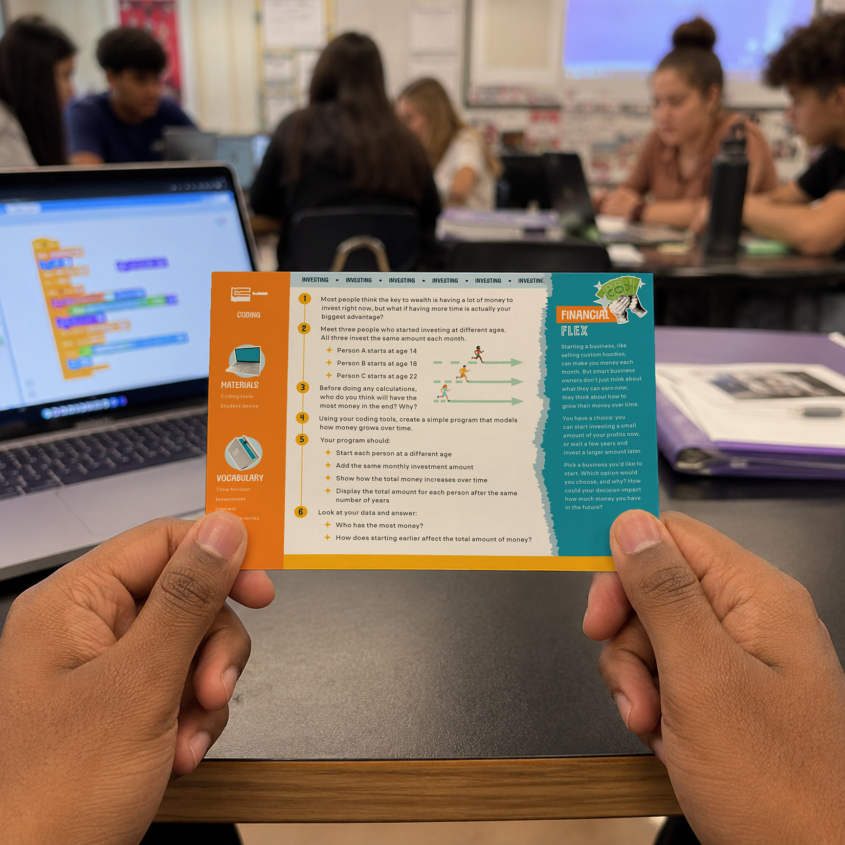 A teenager reads the step-by-step instructions on a Financial Literacy Money Management card as he works on coding.